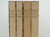 trois livres sont empilés sur une surface blanche