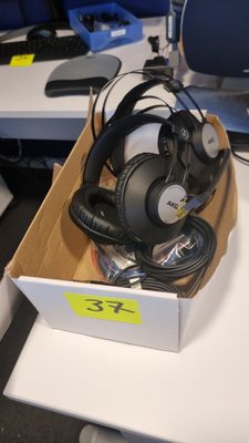 une boîte contenant plusieurs casques audio, posée sur un bureau