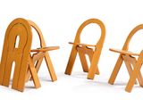 trois chaises en bois assises l'une à côté de l'autre sur une surface blanche
