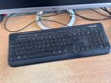 a computer keyboard and a monitor on a desk