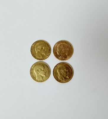 quatre types différents de pièces d'or reposant sur une surface blanche