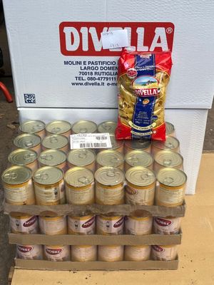 a box of cans of beer and a bag of chips on a table