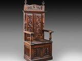 une vieille chaise en bois dont le dossier et l'assise sont sculptés