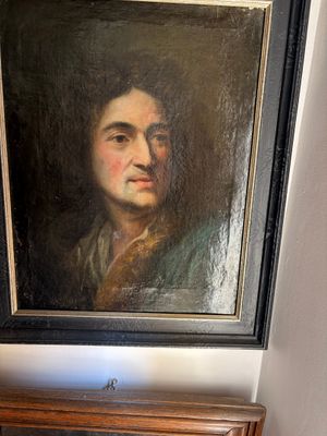 a painting of a man that is hanging on the wall