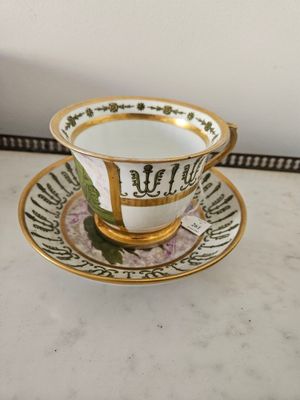 tasse à thé et soucoupe ornées d’une bordure dorée et d’un motif floral