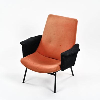 une chaise orange et noire posée sur une surface blanche, avec un fond blanc