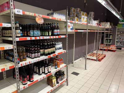 many bottles of beer on the shelves in the store