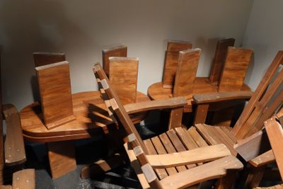 many wooden chairs and a table in a room