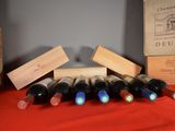 several bottles of wine are lined up on a red table cloth