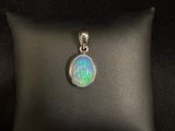 a white oplite pendant sitting on top of a black pillow