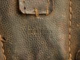 a close up of a brown leather bag with a tag on it