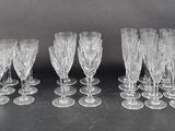 six clear wine glasses are lined up on a black surface