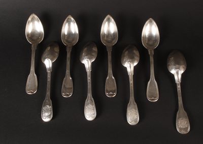 six silver spoons are lined up in a row on a black surface