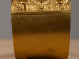 an antique brass box on a wooden table with a gray background