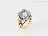 a close up of a ring with a blue topaz stone in it