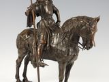 statue of a man on a horse with a flag on a stand