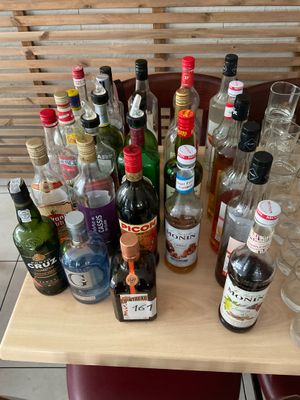 many bottles of alcohol sitting on a table next to each other