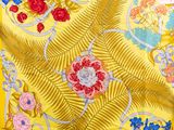 an image of a close up of a yellow scarf with flowers and leaves