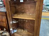un meuble en bois avec une porte en verre dans une pièce