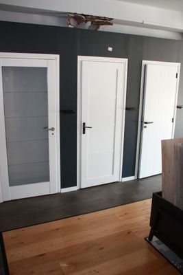 doorways and doors in a room with hardwood floors and a television