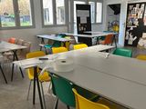 brightly colored chairs and tables in a large open room with windows