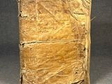an old book sitting on top of a table covered in paper