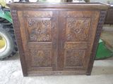 une armoire en bois ornée de sculptures, dans un garage