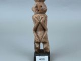 une petite statue en bois représentant un homme coiffé d'un chapeau