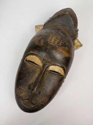 une image d'un masque en bois accroché au mur