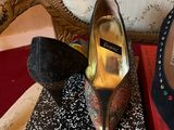 pair of black and gold high heeled shoes sitting on top of a book