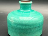 a green vase that is sitting on a table