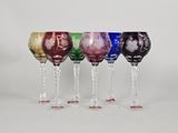 four wine glasses are lined up in a row on a white surface