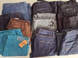 many pairs of jeans that are sitting on a table