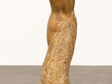 statue of a woman in a long dress standing on a concrete floor