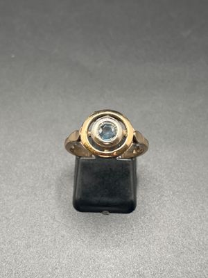 Gros plan sur une bague en or ornée d'une topaze bleue