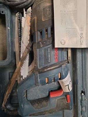 une photo d'une boîte à outils contenant une scie et d'autres outils