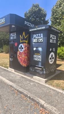 une boîte noire décorée de pizzas, posée sur le bord de la route