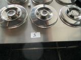 six burners sitting on a stove top in a kitchen