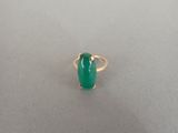 Gros plan sur une bague ornée d'une pierre verte
