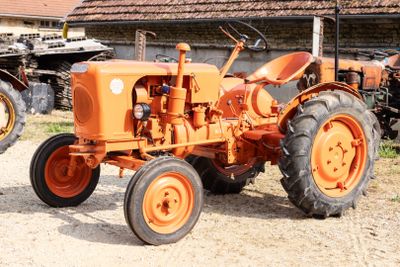 deux tracteurs orange garés l'un à côté de l'autre devant un bâtiment