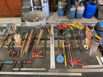de nombreux outils qui traînent sur une table dans le garage