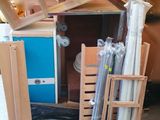 Dans une pièce, des caisses et des échelles sont empilées les unes sur les autres.