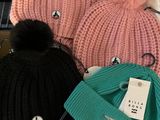 several hats are sitting on top of a table with a laptop in the background