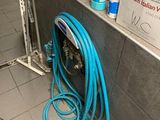 un tuyau bleu posé par terre près d'un mur