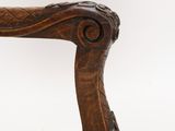 a wooden chair with a carved back and arms