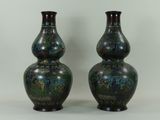 une paire de vases posés l'un à côté de l'autre sur une surface blanche