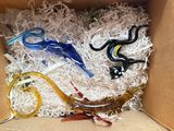 a cardboard box filled with assorted glass figurines