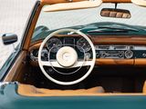 a green convertible car with a steering wheel and dashboard