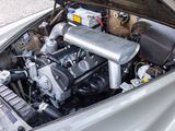 a silver car with a engine in the trunk of it