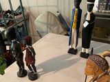several figurines are sitting on a table in a cluttered room